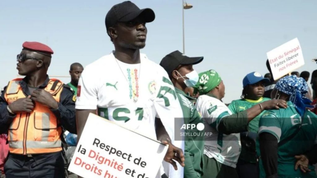 Supporters hold placards as they gather during a demonstration against the detention in Morocco of Senegalese supporters following incidents during the Africa Cup of Nations, in Dakar on February 28, 2026. Around 250 protesters marched through Dakar on February 28, 2026 in support of 18 football fans jailed in Morocco following incidents during the final of the African Nations Cup in January