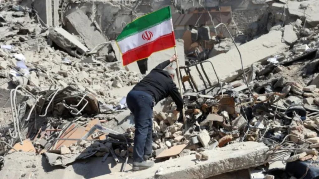 Iranian man placing a flag on rubble amid city destruction, Tehran