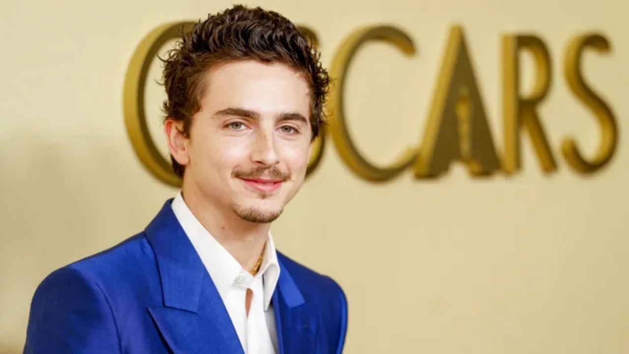 Timothée Chalamet in bright blue suit posing at Oscars 2026 nominees luncheon.