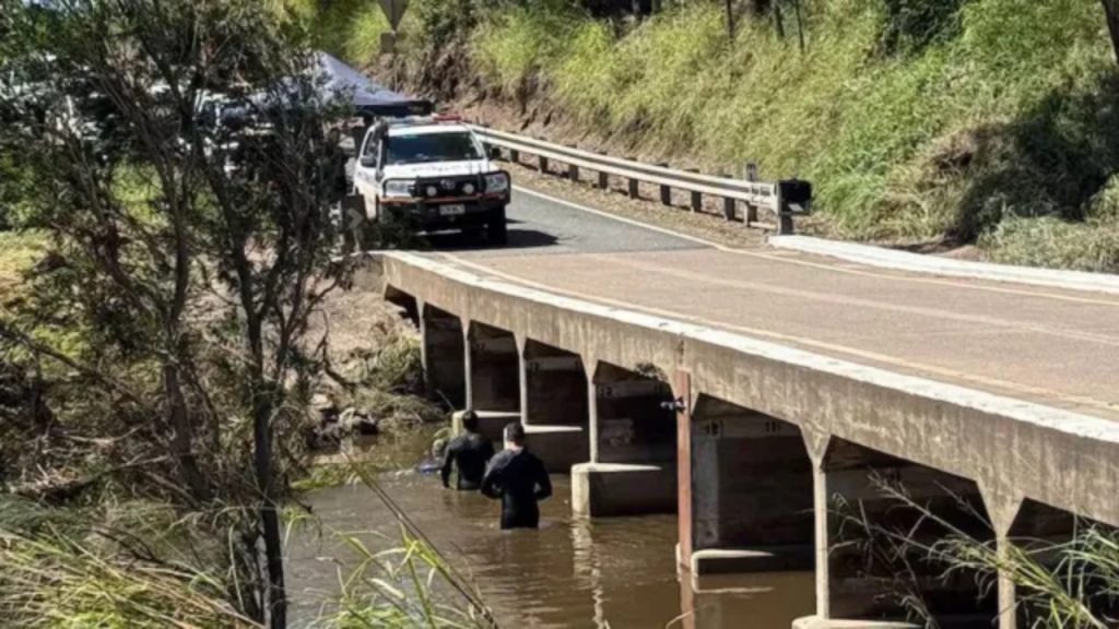 Rescue workers searching floodwaters near Kilkivan, Queensland, where two Chinese backpackers were found inside a submerged vehicle.