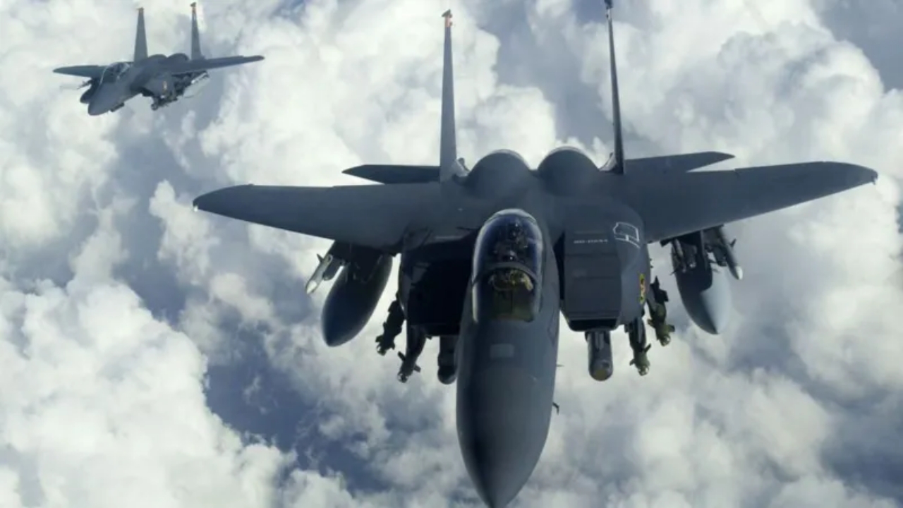 US F-15E Strike Eagle jets flying through cloudy sky over mountains - National News
