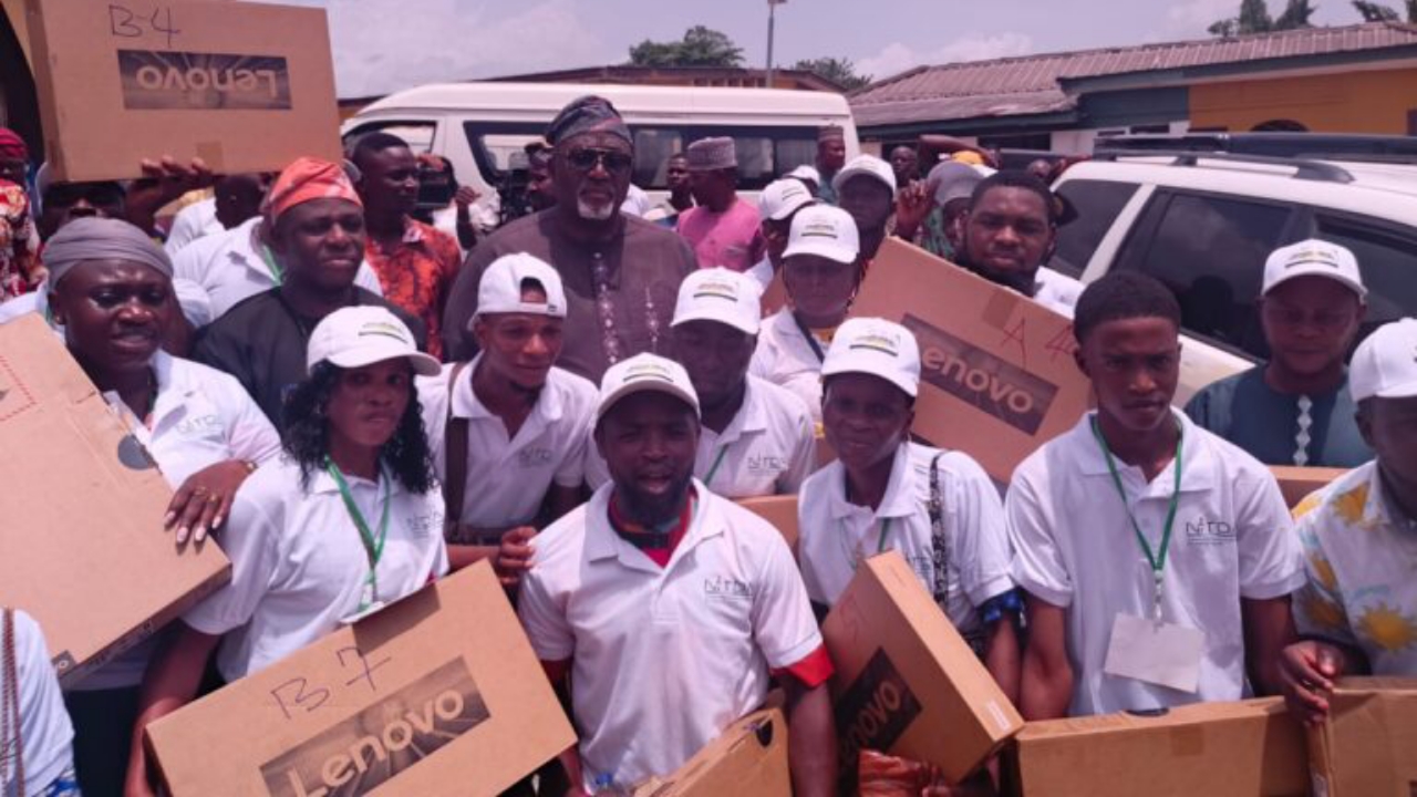 Rep member, Stanley Olajide (middle with glasses) and some of the beneficiaries holding the laptops after the programme in Ibadan - National News