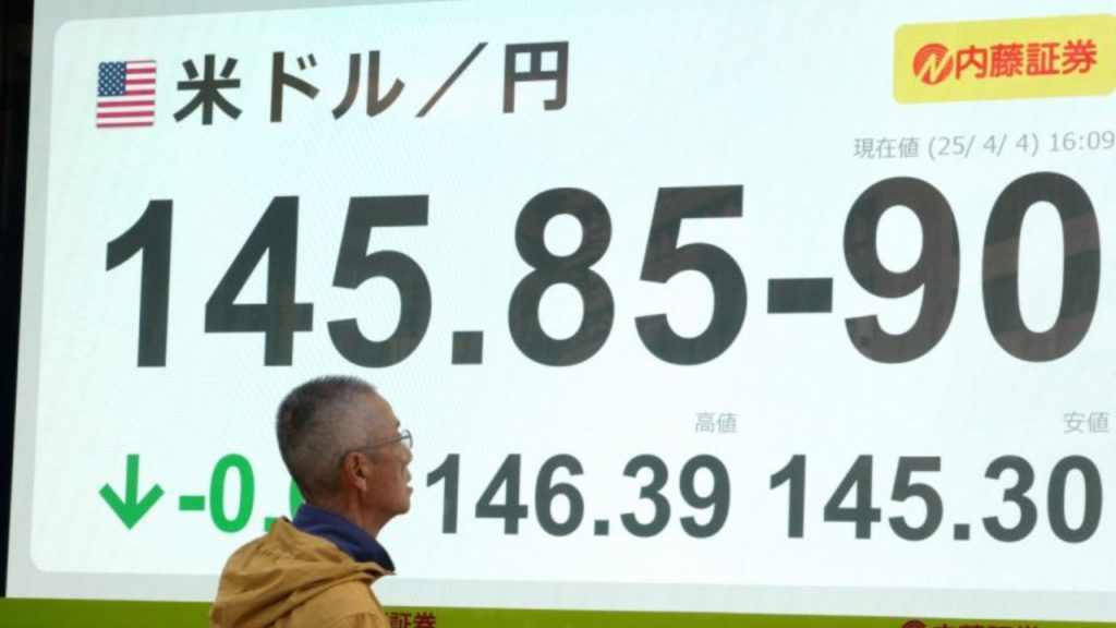 A man looks at an electronic board showing the foreign exchange trading price of the Japanese yen against the US dollar on a street in Tokyo on April 4, 2025 - National News
