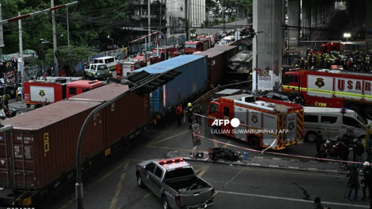 Police officers, rescue workers and firefighters stand at the site of a train collision with a bus underneath Makkasan Airport Rail station in Bangkok on May 16, 2026. A collision between a freight train and a bus killed at least eight people and injured more than 30 in the Thai capital Bangkok, emergency services said - National News