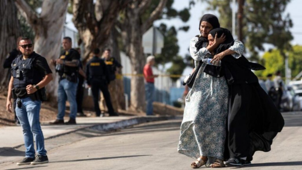 Two women react as they leave a reunification center following the shooting at the Islamic Center of San Diego in southern California, on May 18, 2026. A shooting at the largest mosque complex in San Diego killed three people, with two suspected teenage gunmen later found dead in a car from self-inflicted gunshot wounds, police said - National News