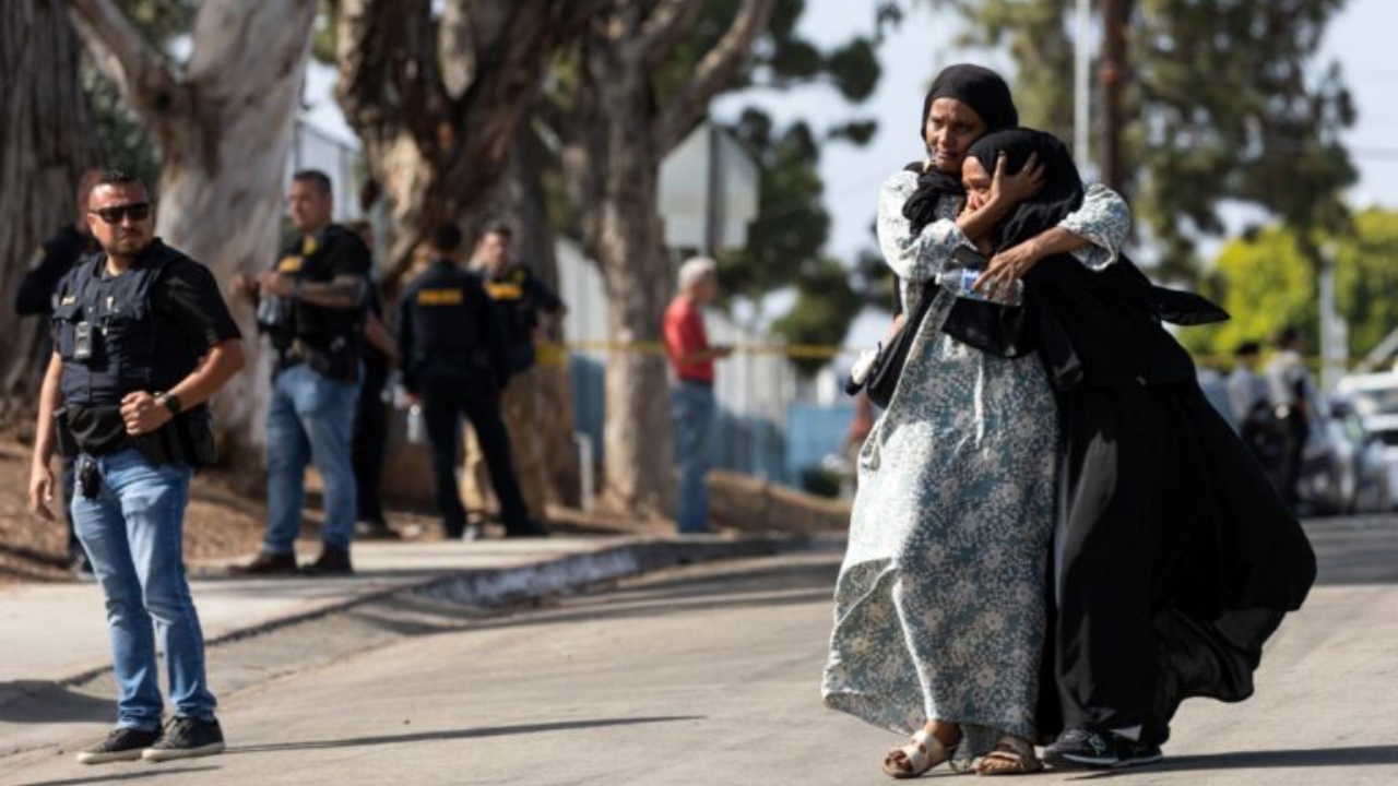 Two women react as they leave a reunification center following the shooting at the Islamic Center of San Diego in southern California, on May 18, 2026. A shooting at the largest mosque complex in San Diego killed three people, with two suspected teenage gunmen later found dead in a car from self-inflicted gunshot wounds, police said - National News